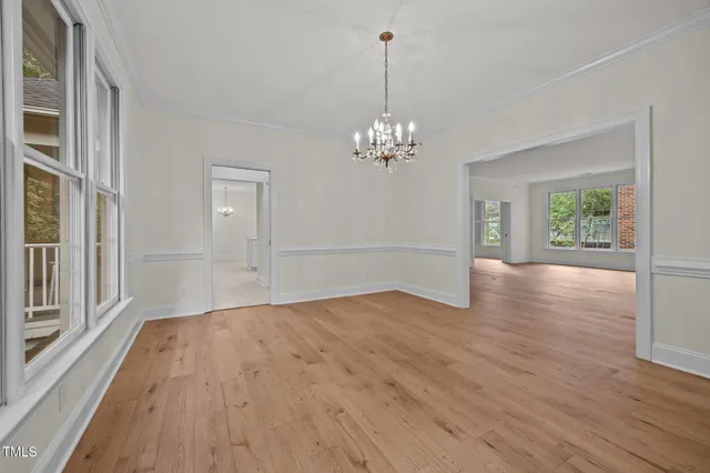 a view of a room with wooden floor and chandelier