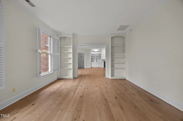 a view of a hallway with wooden floor and closet area