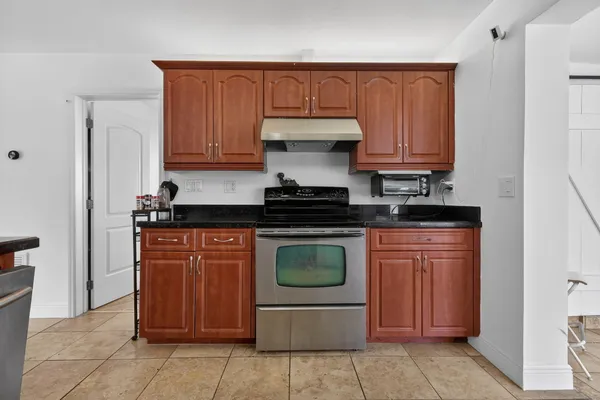 a kitchen with stainless steel appliances granite countertop a refrigerator and a stove top oven