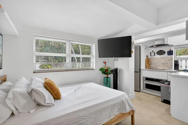 a living room with furniture a mirror and a fan