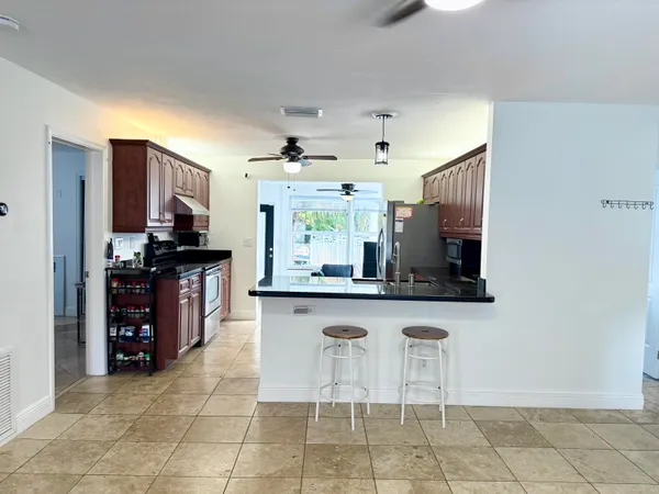 a kitchen with stainless steel appliances granite countertop a stove a refrigerator and a sink