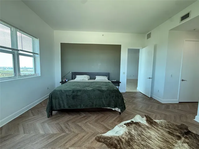 a bedroom with a bed and wooden floor