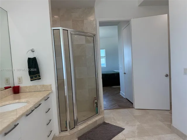 a bathroom with a granite countertop sink and a mirror