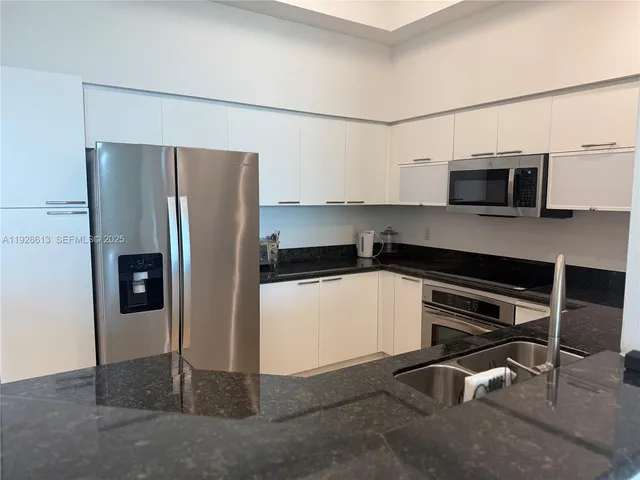 a kitchen with stainless steel appliances a refrigerator and microwave