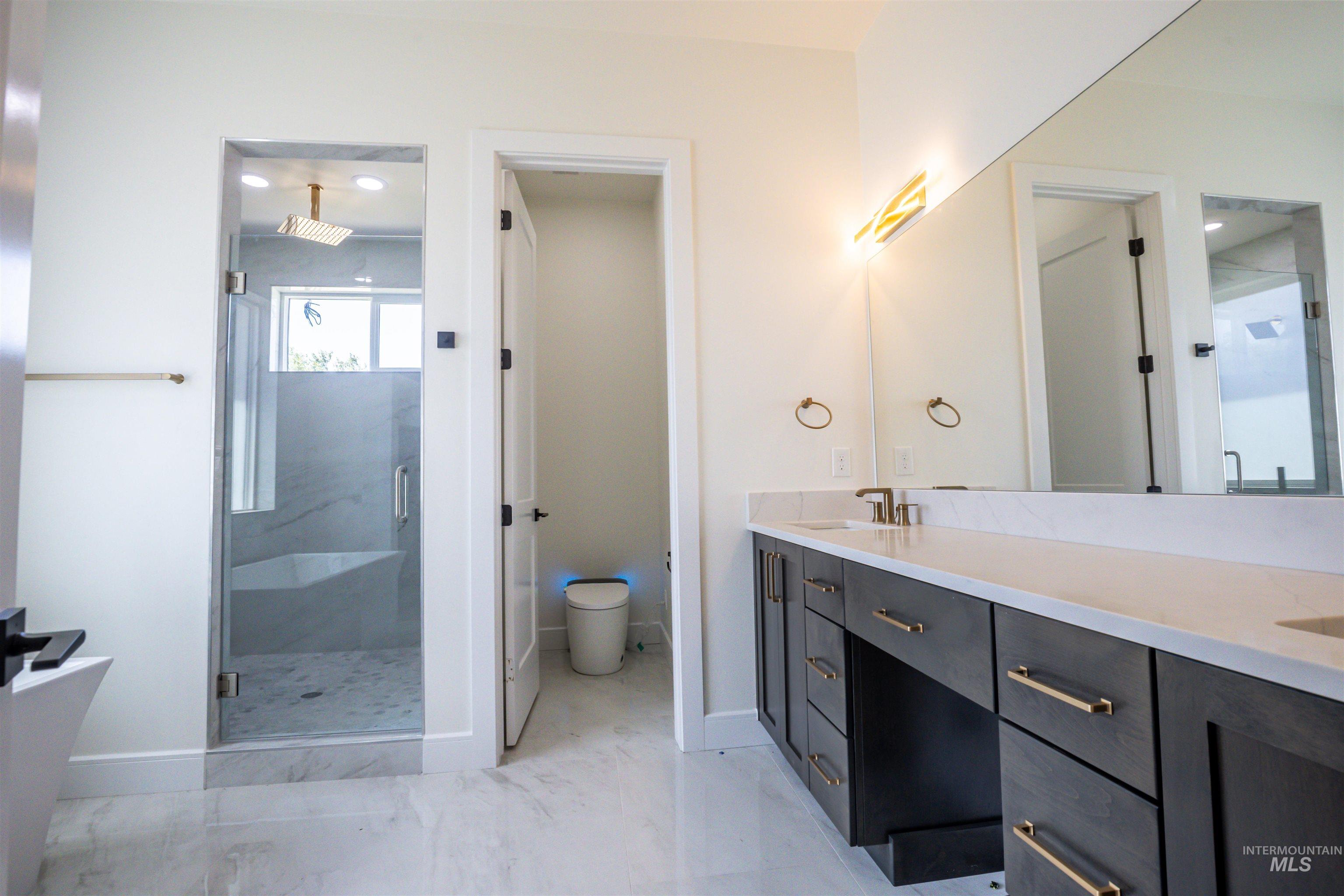 23904 Southview Lane Middleton, ID 83644 - Photo 10 of 29 Spacious bathroom featuring a dual vanity with a light-toned countertop, dark wood-finish cabinetry, and gold-toned hardware