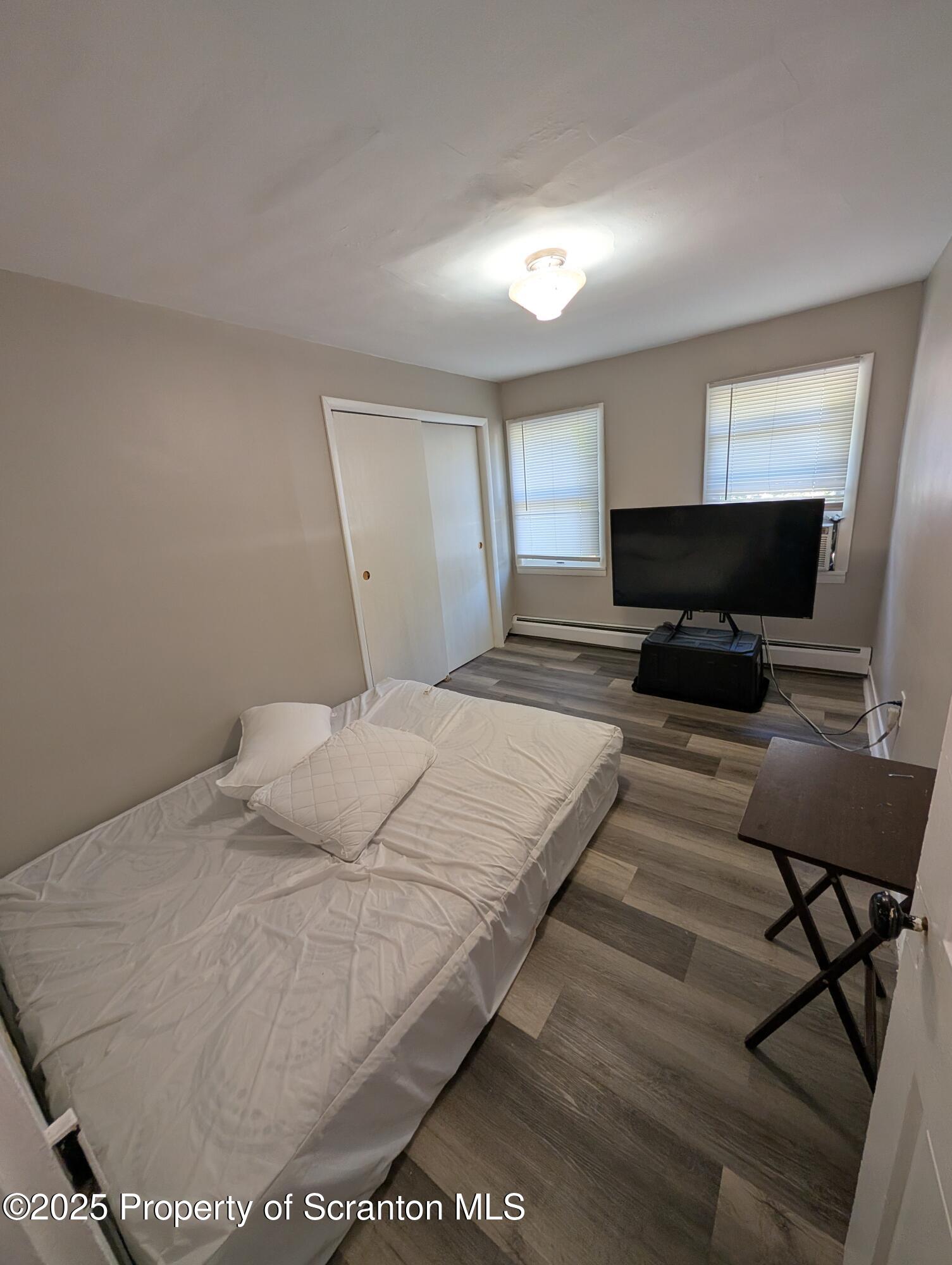 2133-2135 Jackson Street Scranton, PA 18504 - Photo 13 of 38 a bedroom with a bed and wooden floor