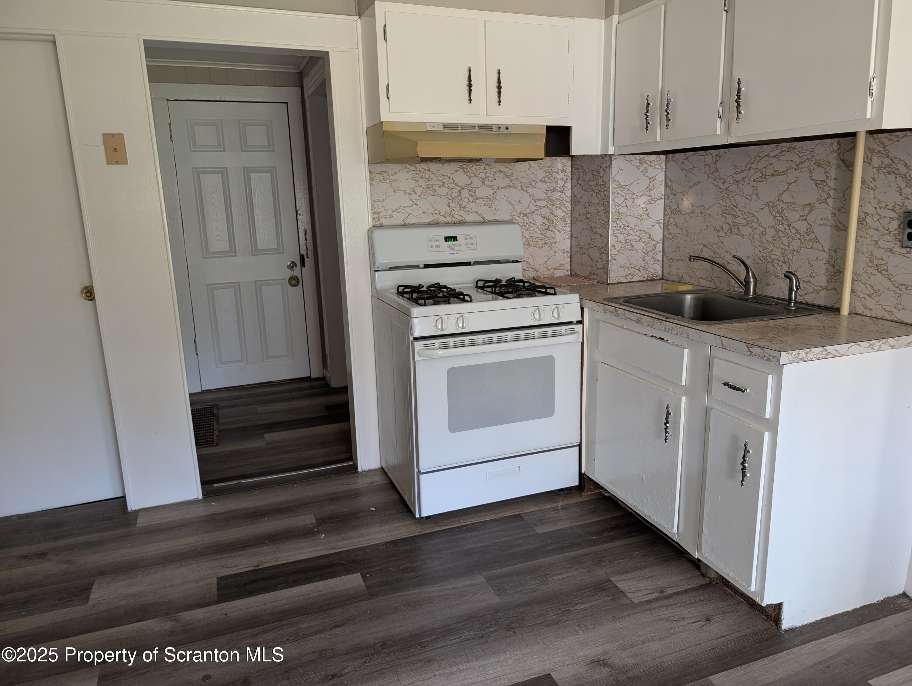 2133-2135 Jackson Street Scranton, PA 18504 - Photo 20 of 38 a kitchen with a sink cabinets and a wooden floor