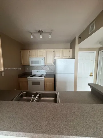 a kitchen with a refrigerator a sink and cabinets
