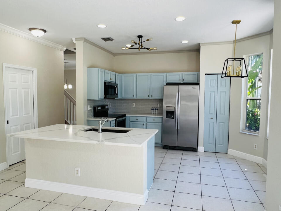 6610 Windmill Way Greenacres, FL 33413 - Photo 11 of 40 a kitchen with stainless steel appliances a refrigerator sink microwave and cabinets
