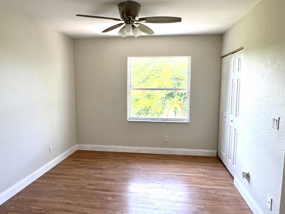 6610 Windmill Way Greenacres, FL 33413 - Photo 16 of 40 wooden floor in an empty room with a window