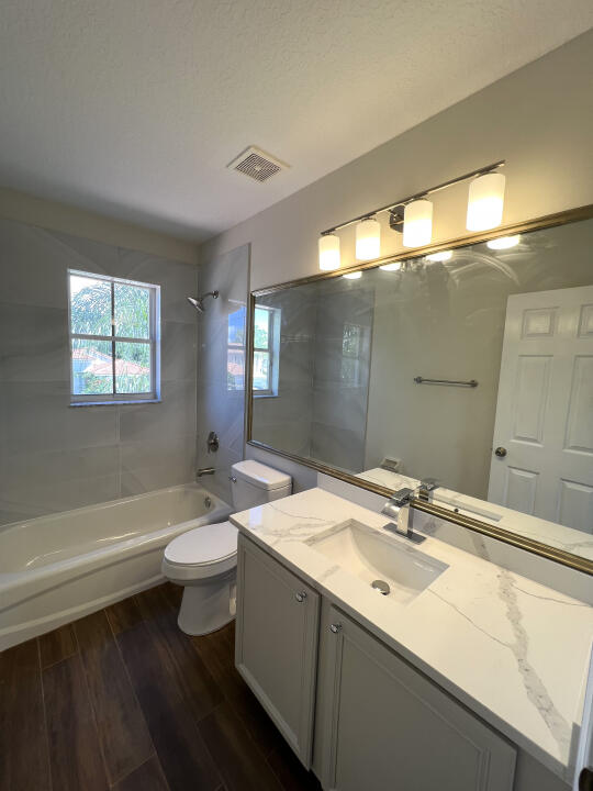 6610 Windmill Way Greenacres, FL 33413 - Photo 19 of 40 a bathroom with a double vanity sink toilet and shower