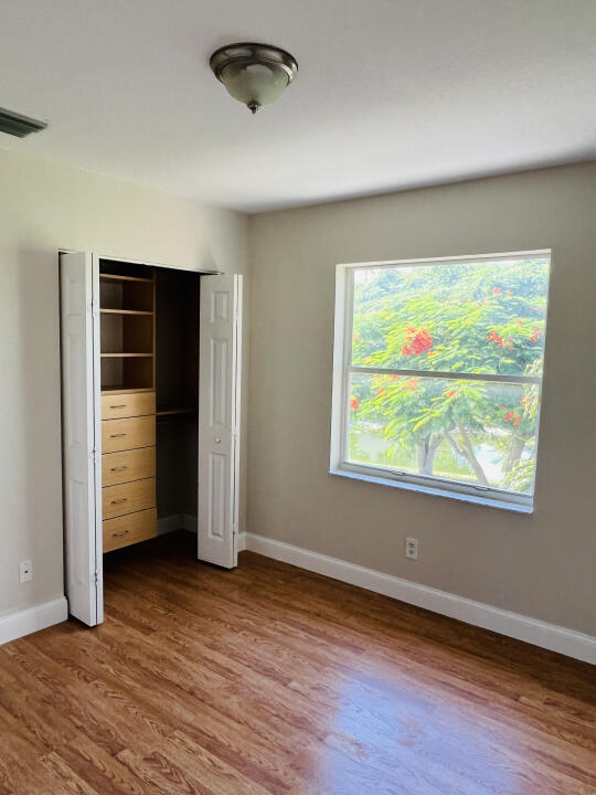 6610 Windmill Way Greenacres, FL 33413 - Photo 21 of 40 an empty room with wooden floor and windows