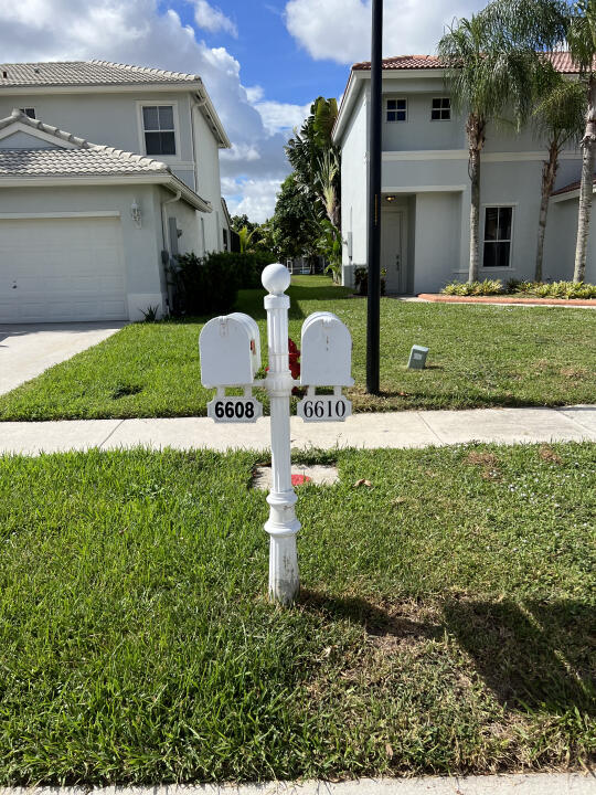 6610 Windmill Way Greenacres, FL 33413 - Photo 39 of 40 a front view of a house with a yard and garage