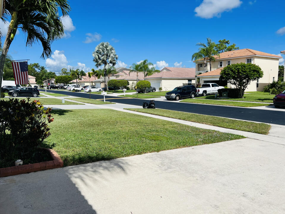 6610 Windmill Way Greenacres, FL 33413 - Photo 40 of 40 a front view of a house with swimming pool garden and trees
