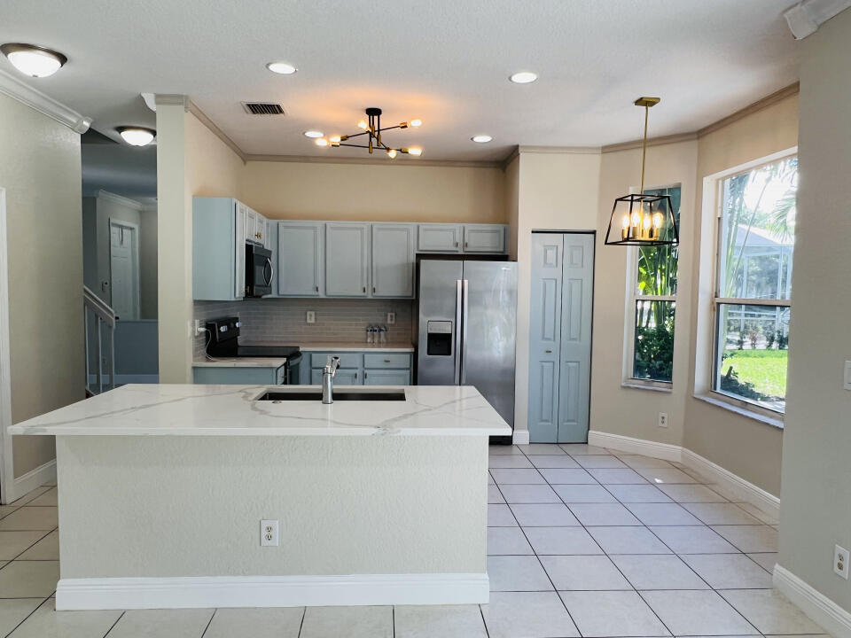 6610 Windmill Way Greenacres, FL 33413 - Photo 7 of 40 a kitchen with stainless steel appliances a refrigerator sink and microwave