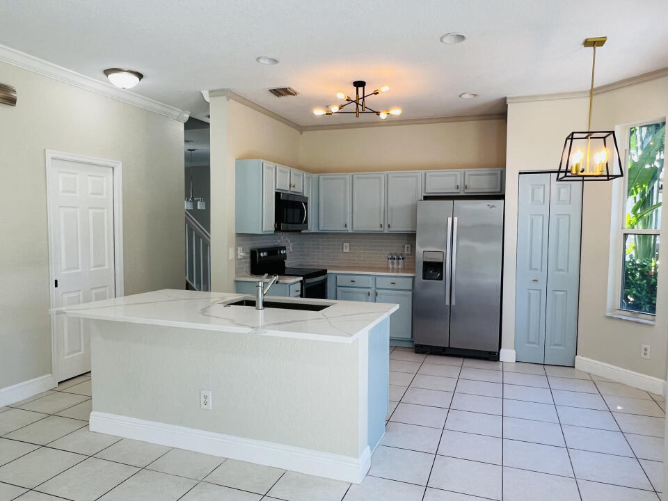 6610 Windmill Way Greenacres, FL 33413 - Photo 10 of 40 a kitchen with kitchen island a sink stainless steel appliances and counter space
