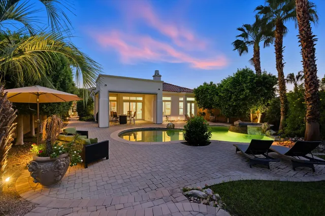 a view of a house with swimming pool and sitting area
