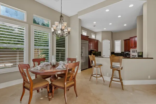 a kitchen with stainless steel appliances granite countertop a refrigerator and a stove top oven with wooden floor