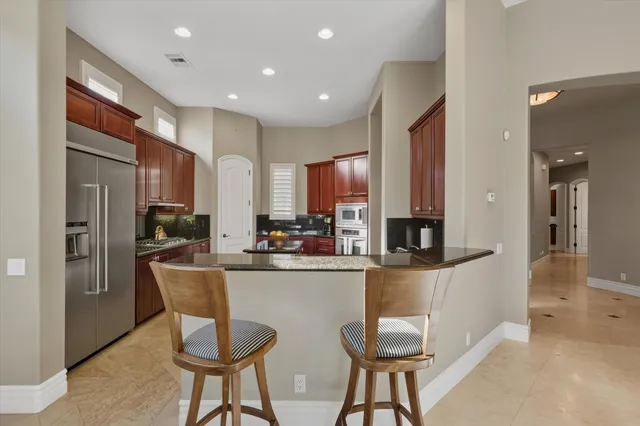 a kitchen with stainless steel appliances granite countertop a sink stove and refrigerator