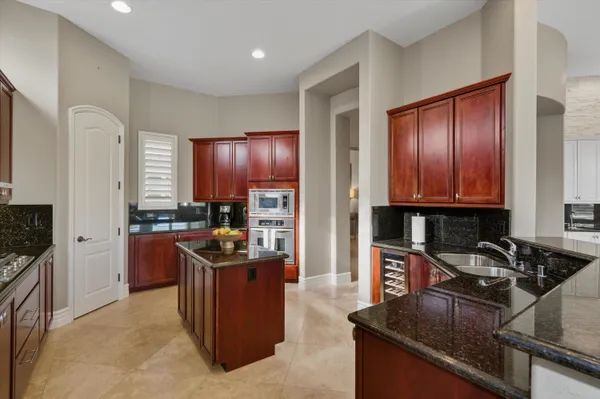 a kitchen with granite countertop a refrigerator and a stove