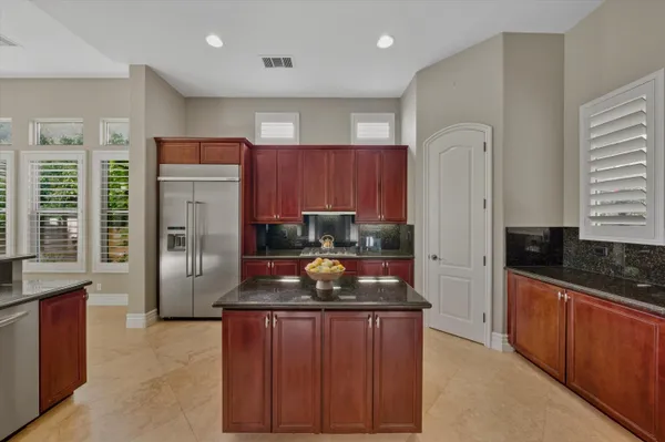 a kitchen with stainless steel appliances granite countertop a sink stove and refrigerator