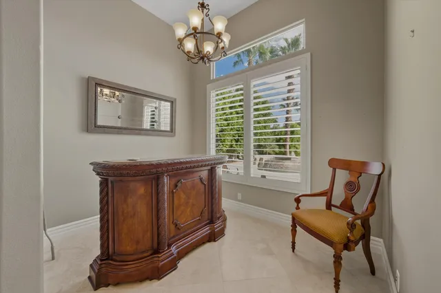 a view of a hallway with dining room and chandelier