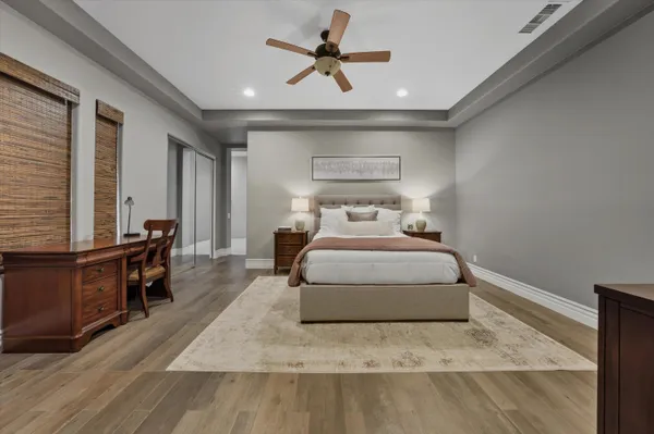 a bedroom with a large bed and the ceiling fan