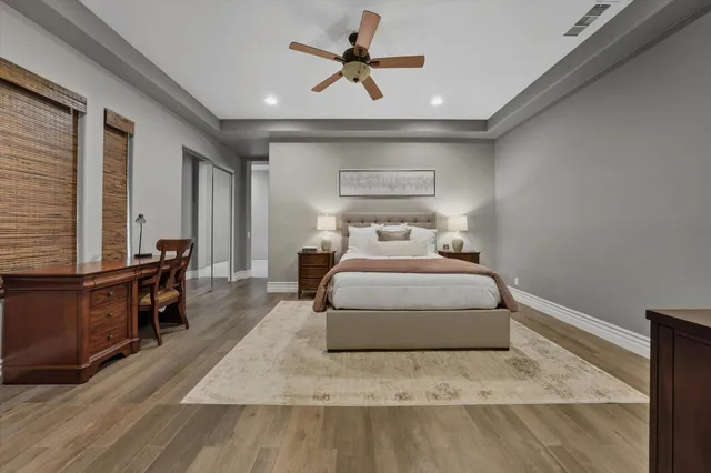 a bedroom with a large bed and the ceiling fan