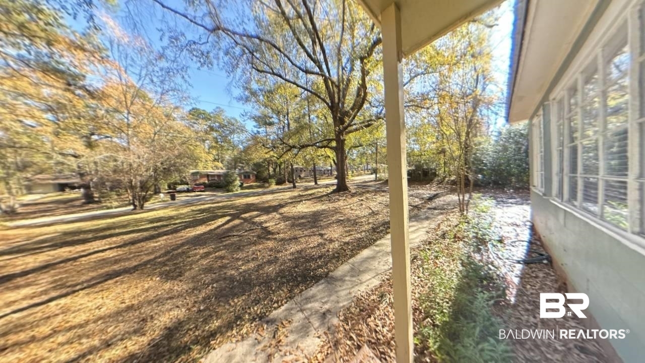 1703 Clark Avenue Bay Minette, AL 36507 - Photo 4 of 27 View of yard featuring a deck and view of scattered trees