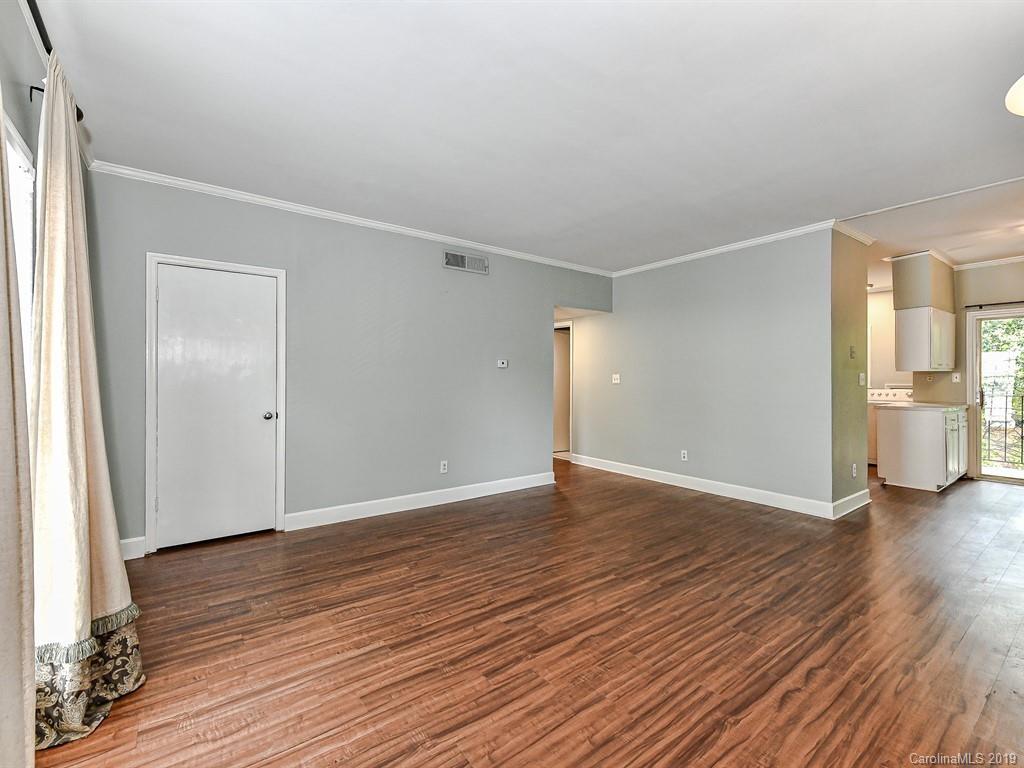 5925 Quail Hollow Road, Unit G Charlotte, NC 28210 - Photo 2 of 19 a view of an empty room with wooden floor and a window