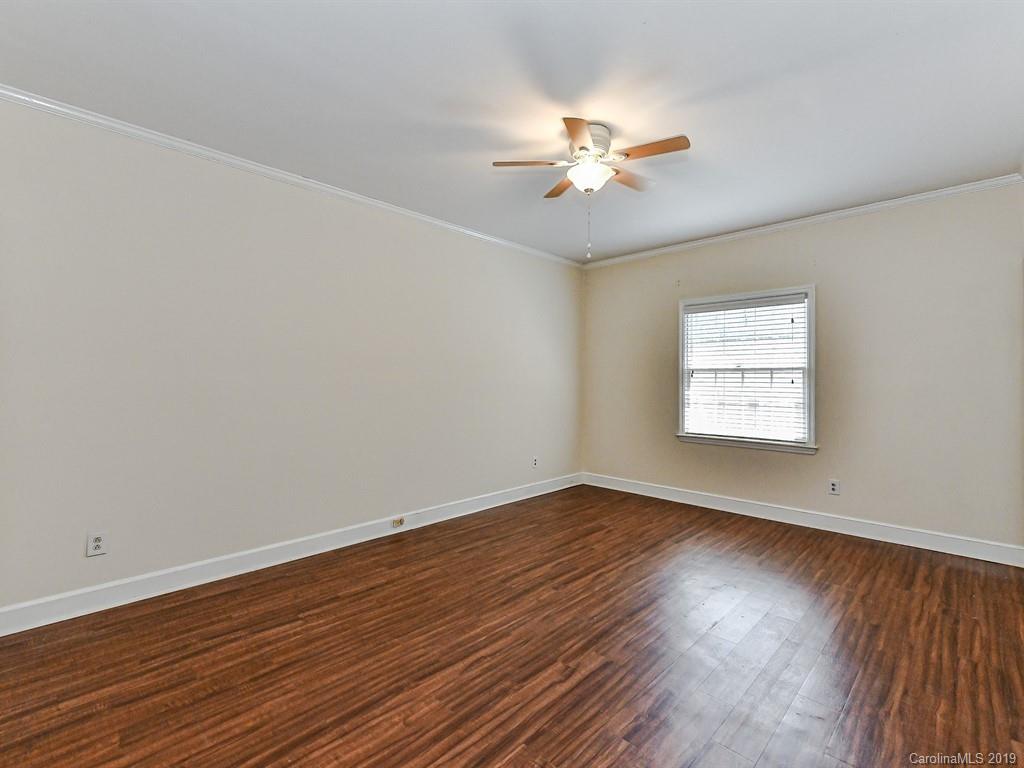 5925 Quail Hollow Road, Unit G Charlotte, NC 28210 - Photo 13 of 19 a view of an empty room with wooden floor and a window