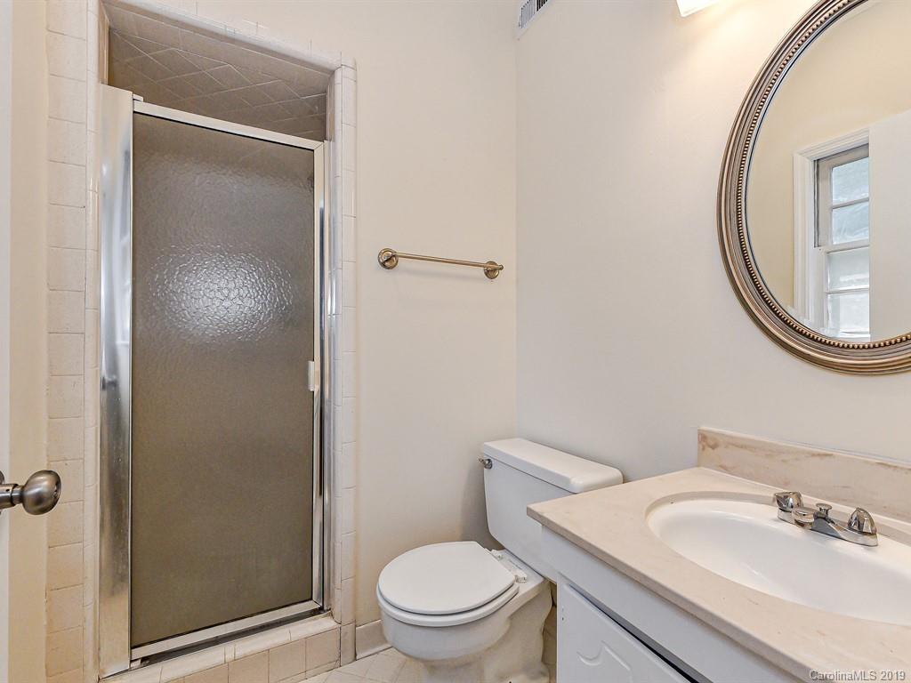 5925 Quail Hollow Road, Unit G Charlotte, NC 28210 - Photo 15 of 19 a bathroom with a sink a toilet and a mirror