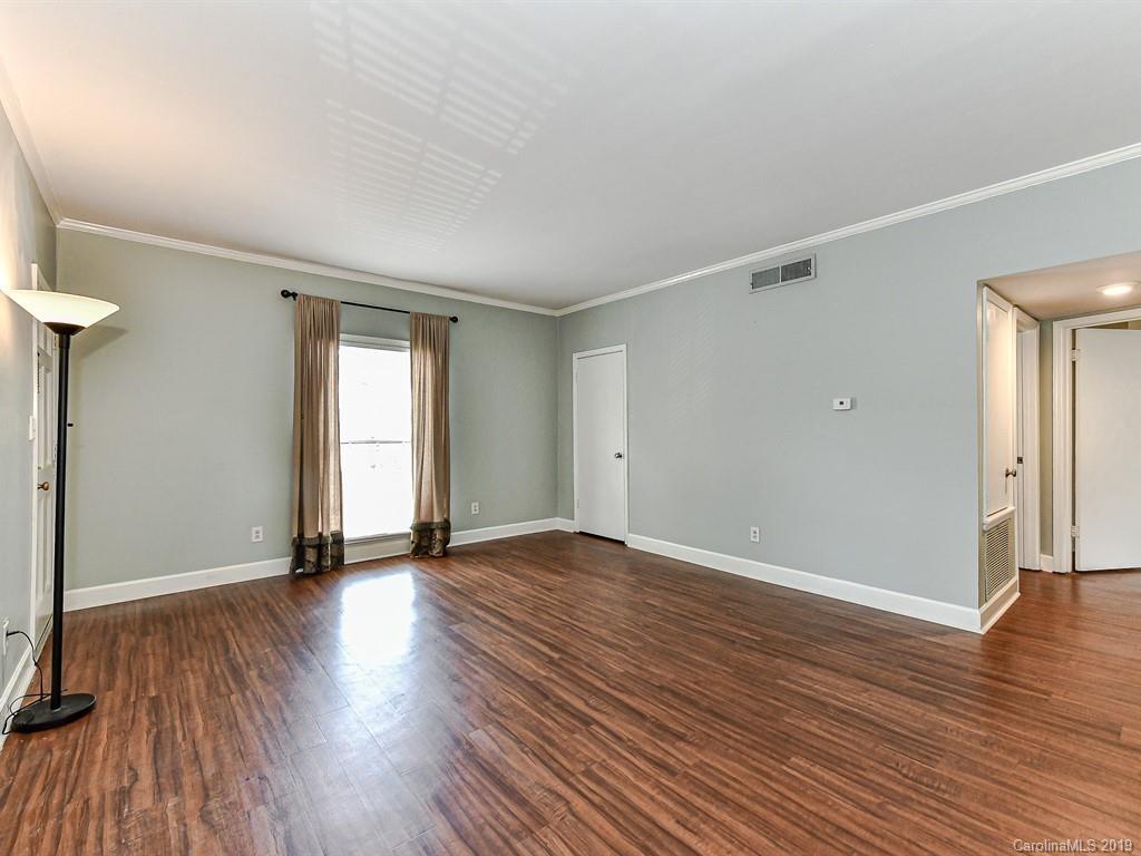 5925 Quail Hollow Road, Unit G Charlotte, NC 28210 - Photo 3 of 19 an empty room with wooden floor and windows