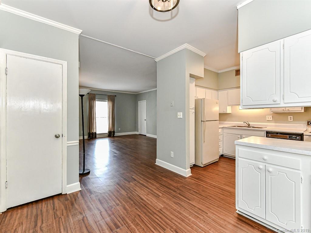 5925 Quail Hollow Road, Unit G Charlotte, NC 28210 - Photo 8 of 19 a kitchen with wooden floors and white cabinets