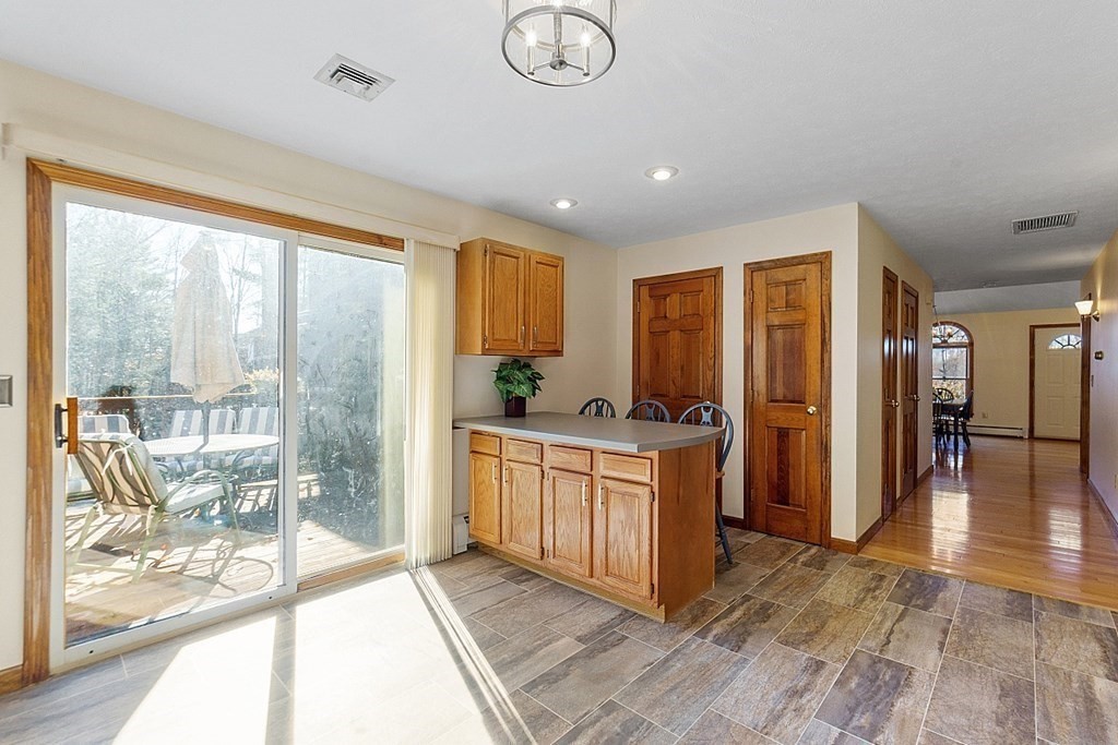 169 Wallace Hill Road Townsend, MA 01469 - Photo 28 of 42 a kitchen with stainless steel appliances granite countertop a refrigerator a sink a stove and white cabinets with wooden floor