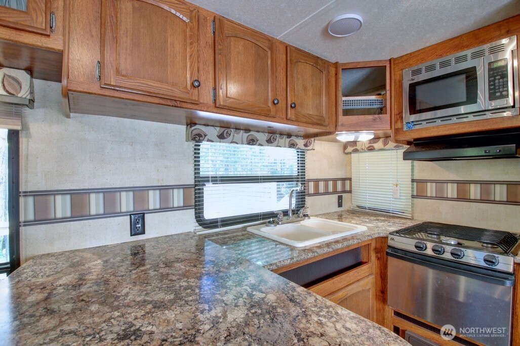 64 Wilderness Way Deming, WA 98244 - Photo 11 of 33 a kitchen with granite countertop a stove and a sink