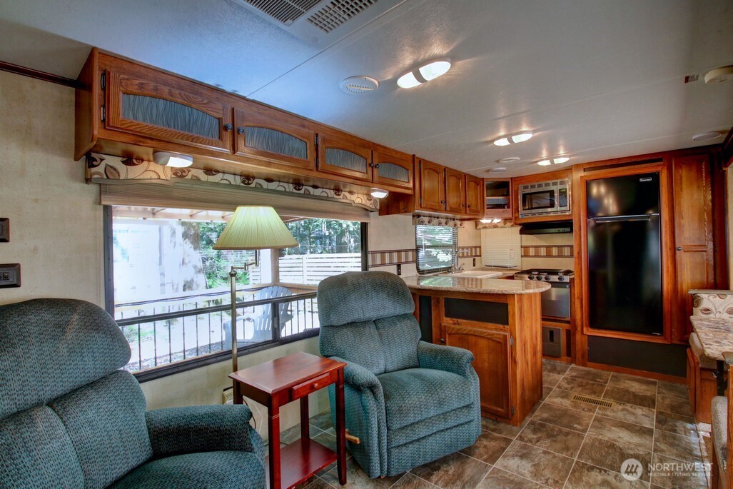 64 Wilderness Way Deming, WA 98244 - Photo 14 of 33 a living room with furniture a ceiling fan and a rug