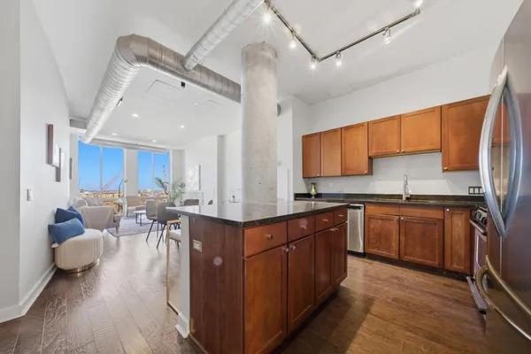 a large kitchen with stainless steel appliances lots of counter space and wooden floor