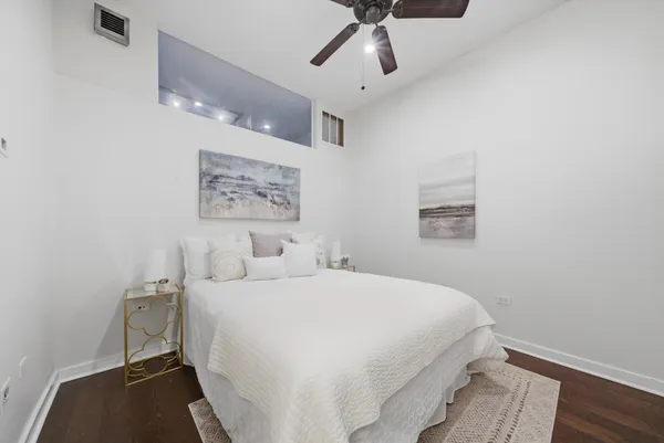 a bedroom with a large bed and a chandelier