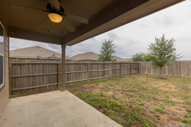 a view of backyard with wooden fence