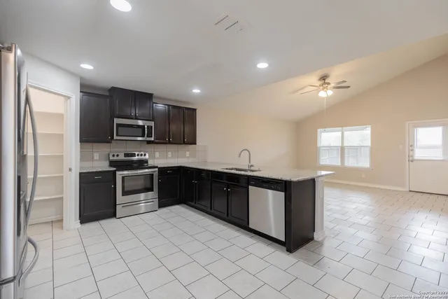 a kitchen with stainless steel appliances granite countertop a refrigerator and a sink