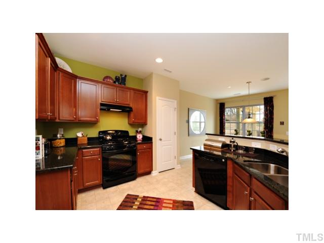 3702 Burtons Barn Street Raleigh, NC 27610 - Photo 4 of 9 Black appliances with granite tops. Knobs on cabinet doors and a Finpod MP3/FM music player located in the kitchen.