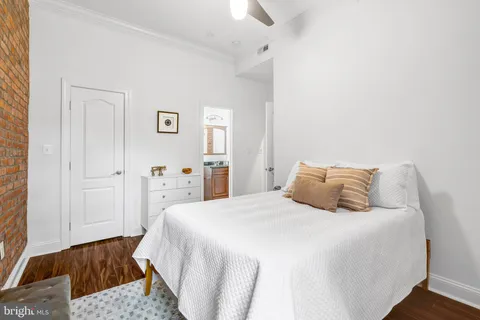 a bedroom with a bed and painting on the wall