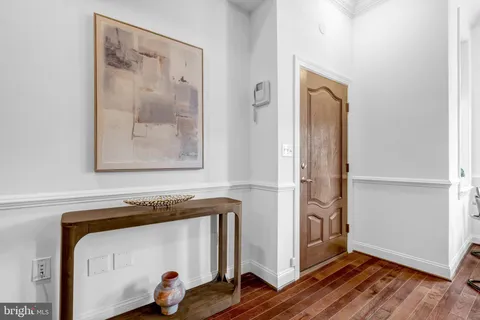 a view of a hallway with wooden floor and door