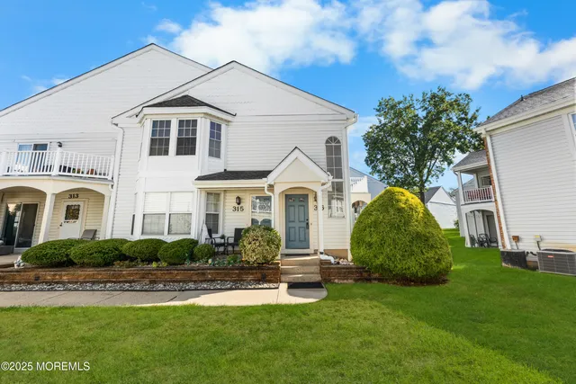 a front view of a house with a garden and plants