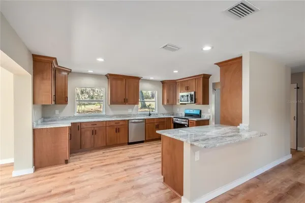 a kitchen with stainless steel appliances granite countertop refrigerator sink and stove