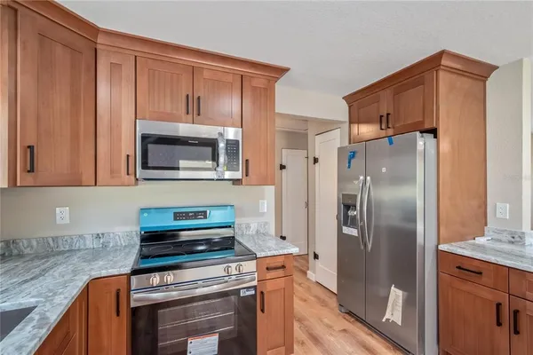 a kitchen with granite countertop a refrigerator stove and washer