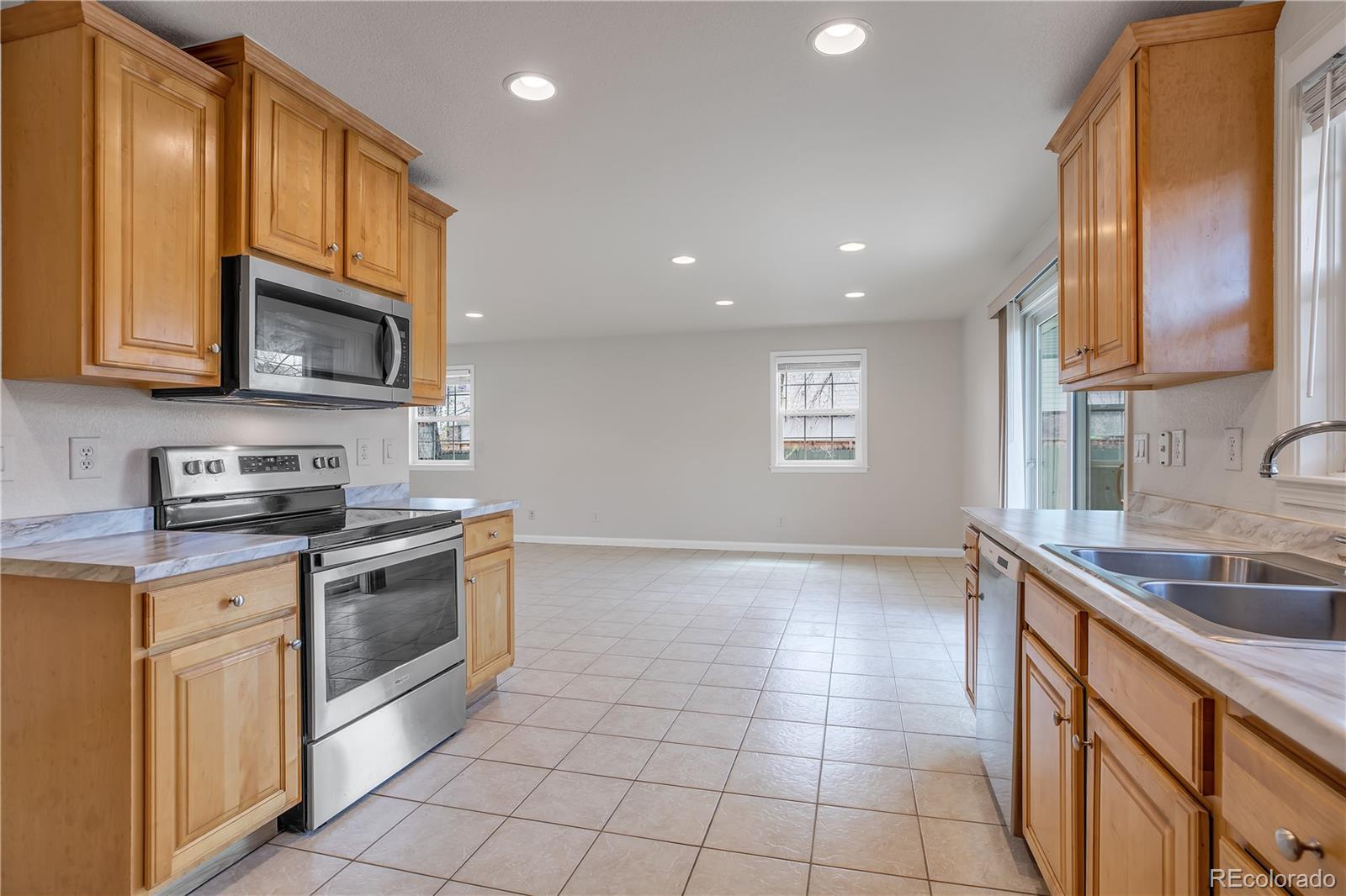 4505 Simms Court Wheat Ridge, CO 80033 - Photo 15 of 37 a kitchen with a sink a stove and cabinets