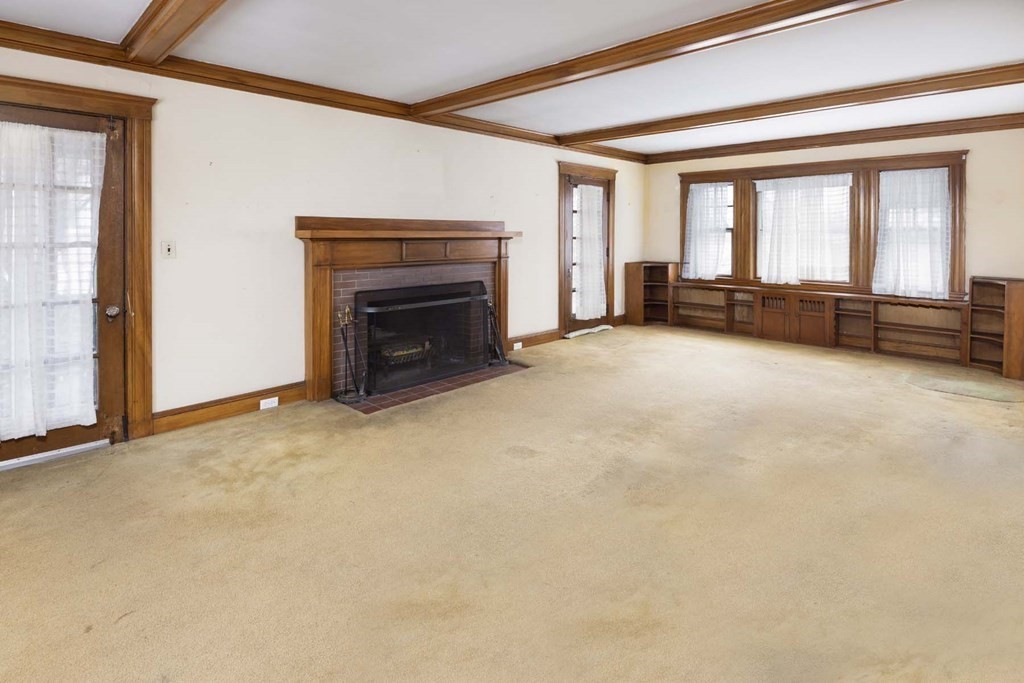 37 Wolcott Road Brookline, MA 02467 - Photo 4 of 12 a view of an empty room with a fireplace and a window