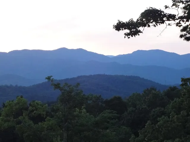 a view of a lush green hillside and a building in the background
